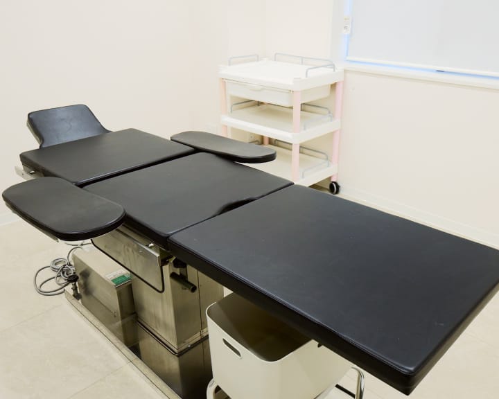 黒いクッションの診察・処置用ベッドが部屋の中央に配置されている